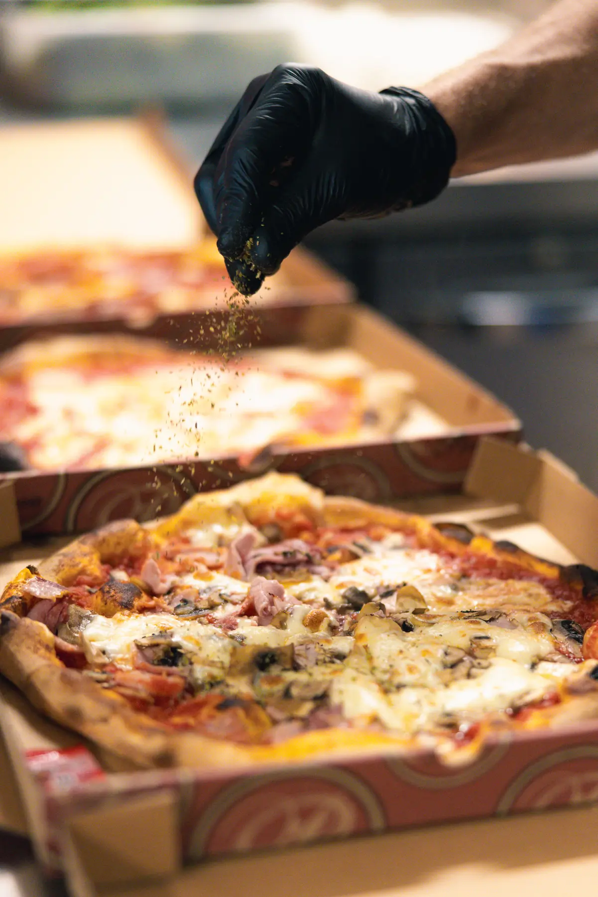 Assaisonnement d’une pizza à emporter préparée au Will