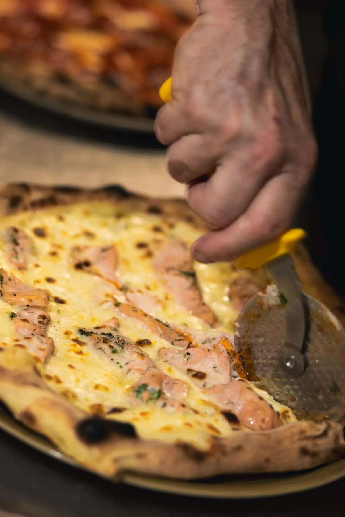 Découpe d’une pizza artisanale préparée au Will