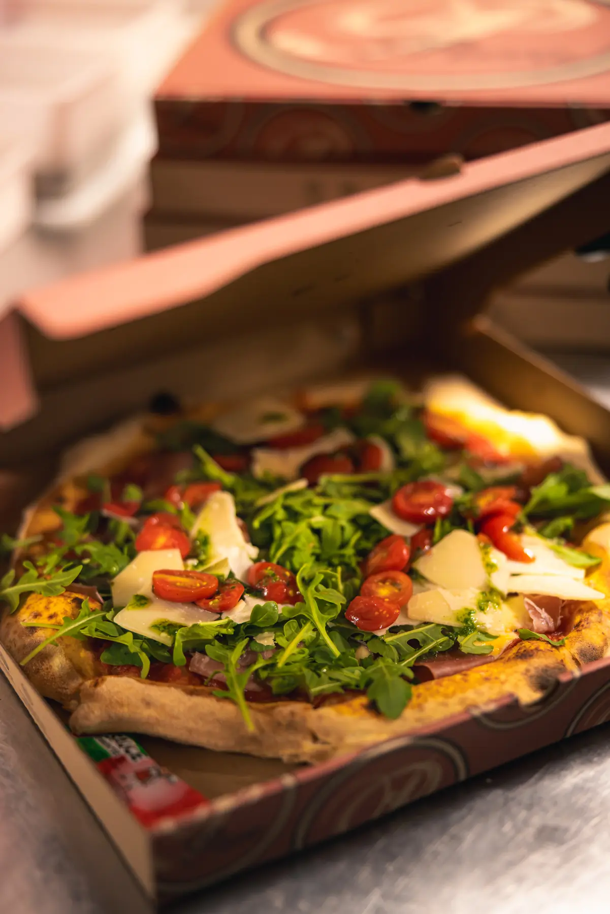 Pizza du Will garnie de roquette, tomates cerises et parmesan